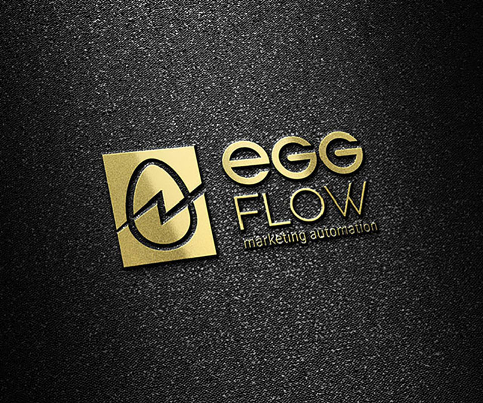 Logo EggFlow ép kim vàng, nổi rõ dấu trứng và đường chảy