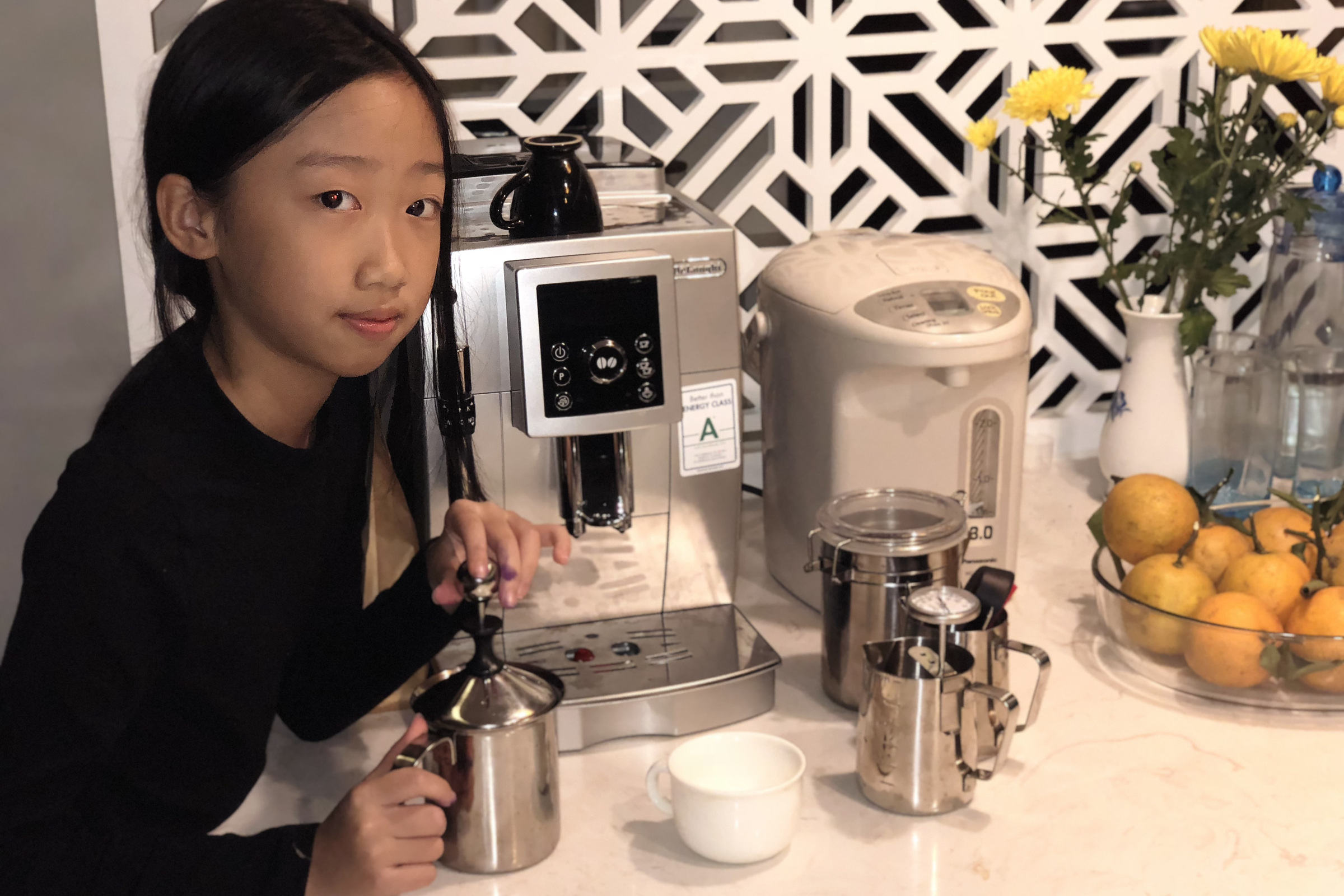 Cô chủ Moon Coffee Bean đánh sữa bên máy espresso tại quầy bếp nhà